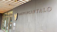 Rovaniemen kaupungintalon edusta, seinässä on kiinni vaakuna ja kaupungin nimikyltti.