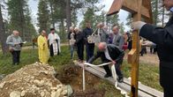 Mies pitelee liinaa, jolla on laskenut arkun hautaan. Kaksi miestä valmistautuu laskemaan pienen jäkäläpintaisen arkun. Kaksi ortodoksipappia seisoo haudan päädyssä ja toisessa päädyssä mies pitelee ortodoksiristiä pystyssä. Saattoväki seuraa tilaisuutta.