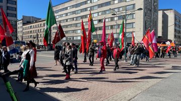 Ihmiset marssivat liput liehuen.