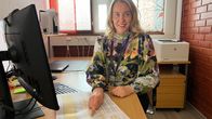 nainen osoittaa aikatauluja toimistossa.