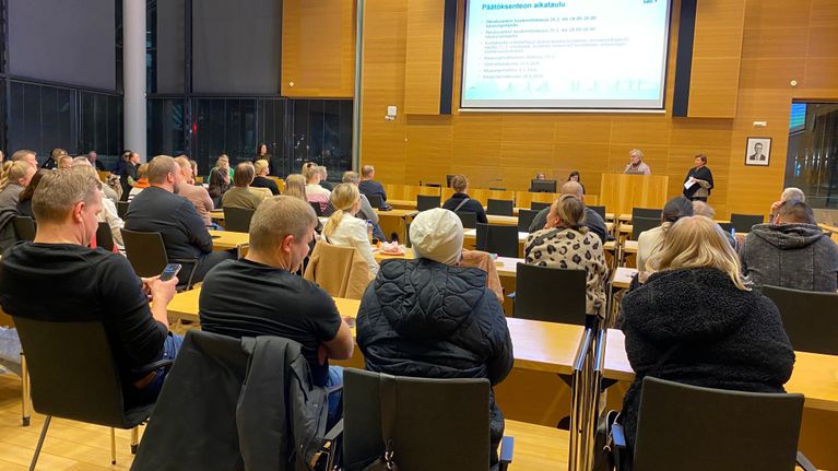 Kaupunkilaiset kuuntelevat Salon kaupungintalolla esitystä koulujen lakkauttamisista.
