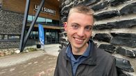 Nuori mies katsoo hymyillen kameraan. 