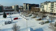 Kauppatori, jossa torikojuja. Talvi. Muutama auto. 