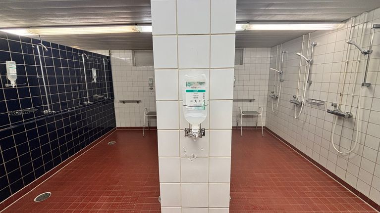 Kuusankosken uimahallin suihkutilat. Seinässä on saippuateline.