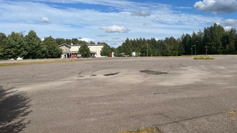 Tyhjä tontti Heinolan Tähtiniemessä, taustalla näkyy puita ja rakennuksia.