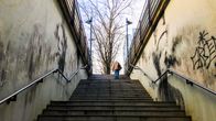 A person walks up a graffiti-covered staircase.
