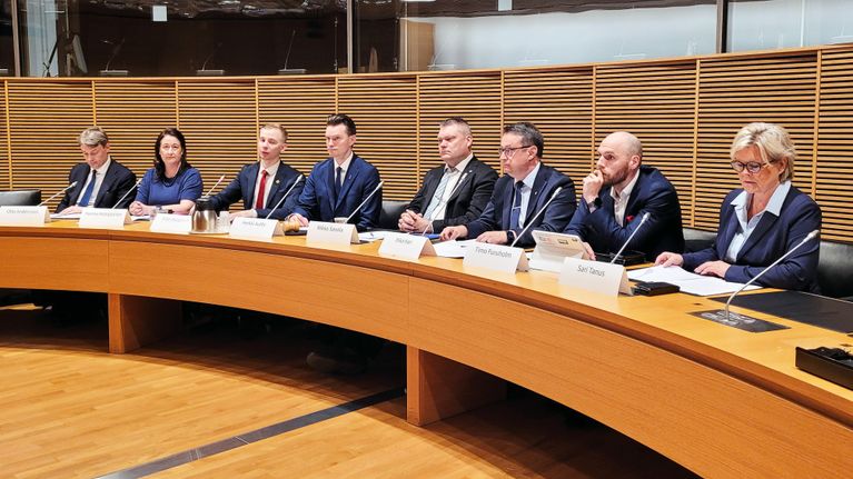 Puolustusvalikunnan jäseniä istumassa tiedotustilaisuudessa.