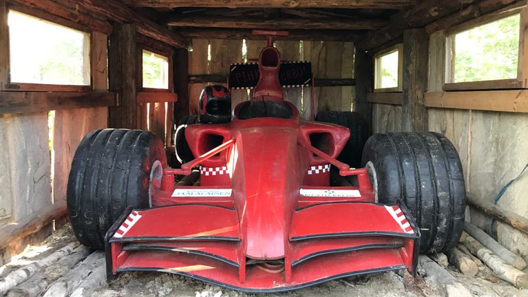 Seppo Laatusen veistämä täysikokooinen puinen punainen Formula 1 auto, kuvattu edestä päin.