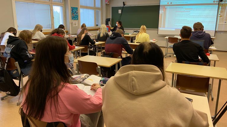 Lukiolaiset istuvat pulpeteissa oppitunnilla.