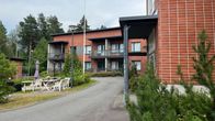 Punatiilinen kaksikerroksinen rakennus, jossa sijaitsee asumisyksikkö.