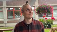 Ruutupaitainen mies katsoo yläviistoon taivaalta putoilevaa sadetta.