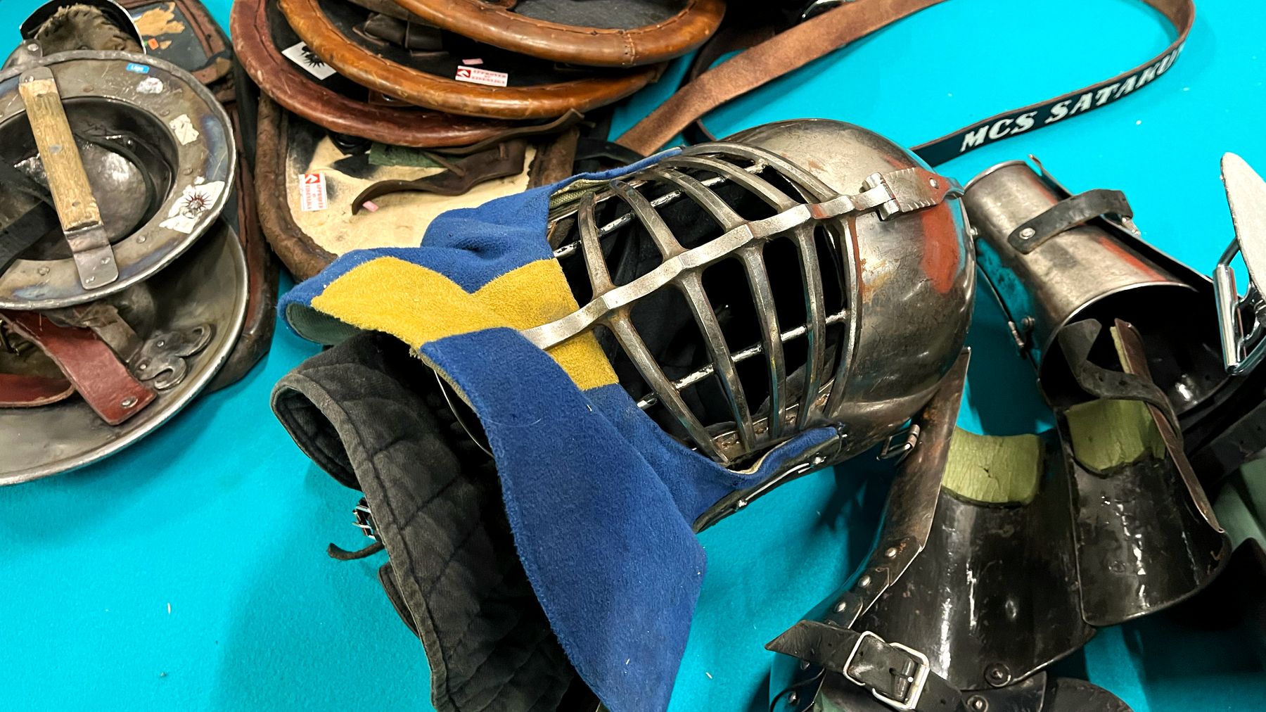 Buhurt varusteita maassa. Kuvassa kypärä, käsisuojuksia ja kilpiä.