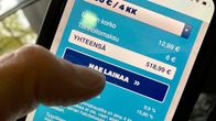Kännykässä näkyy Blue Financen nettisivut, lähikuvassa peukalo on painamassa "hae lainaa" näppäintä.