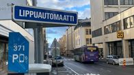 Katunäkymä Kuopiosta, pysäköityjä autoja ja pysäköinnin maksuautomaatti.