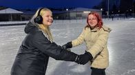 Emilia och Erin håller varandra i händerna medan de skrinner på isen.