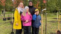 perhe vesslin kirsikkapuunsa vieressä
