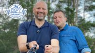 Matias håller i ett kastspö och Micke tittar nyfiket på.
