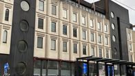 Valkoinen talo, jonka edessä raitiotiepysäkki