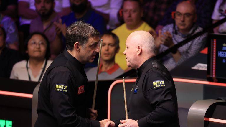 Seitsenkertainen maailmanmestari Ronnie O'Sullivan ja neljästi MM-pokaalia nostanut John Higgins kättelemässä ottelun päätyttyä.