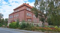 Kuvassa on punaisesta tiilestä rakennettu entinen koulurakennus Pietarsaaressa.