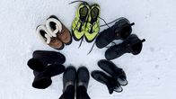 Kuvassa on erilaisia talvikenkiä ympyrässä. Pilkkikengät, nastalenkkarit, lyhytvartiset saappaat, vuorelliset talvikengät