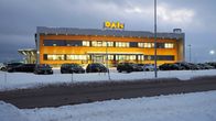 Kaksikerroksinen talo, jossa valokyltti OAK ja etualalla pysäköityjä autoja.