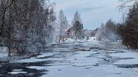 Kruunupyynjoki on vielä osittain sula. Vedenpinnalla jäälauttoja, taustalla rakennus.