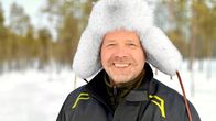 Karvahattupäinen mies hymyilee kameralle. 