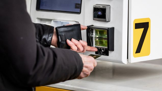 Person putting a credit card into a fuel automat.