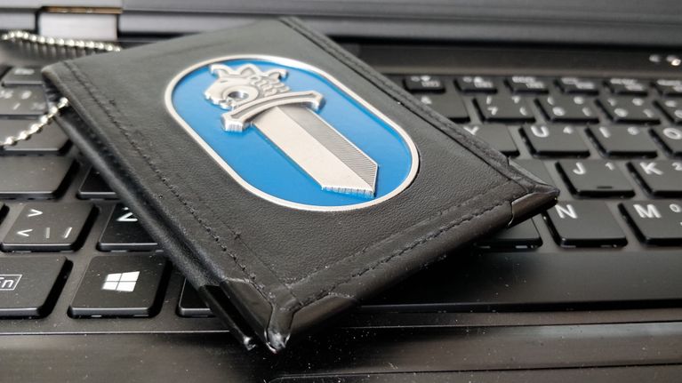 Poliisin virkamerkki tietokoneen näppäimistön päällä. 