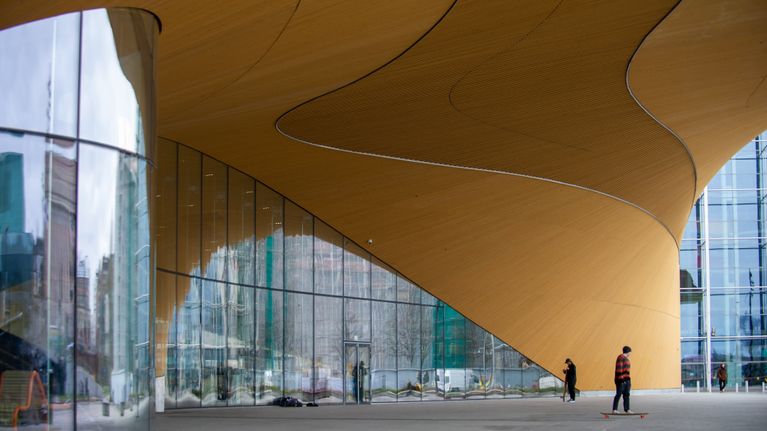 Helsinki Central Library Oodi with skateboarders underneath the canopy.