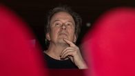 Författaren Kjell Westö sitter på en röd stol på teatern.
