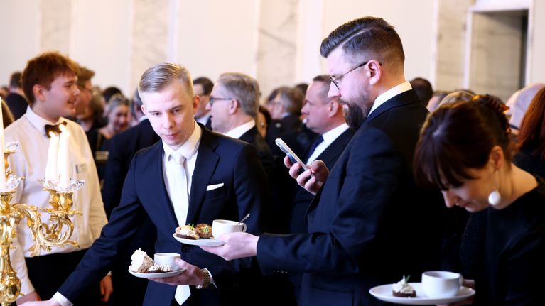 Kansanedustajia eduskunnan valtiosalissa.