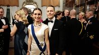 Sanna Marin in a white gown, alongside her husband Markus Räikkönen wearing a tuxedo.