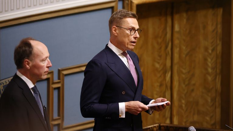 Alexander Stubb puhuu eduskunnassa, Jussi Halla-aho kuuntelee vieressä.