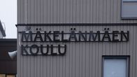 Mäkelänmäen koulun kyltti koulun seinällä. 