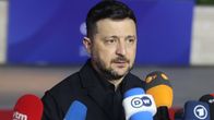 Volodymyr Zelenskyj talar framför en rad mikrofoner från olika ländes mediebolag.