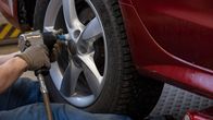rengasasentaja irrottaa auton rengasta mutterinvääntimellä.