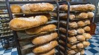Vastaleivottuja leipiä odottamassa pakkausta leipomon hyllyillä.