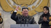 Kim Jong Un nostaa kättään puhujapöntössä.