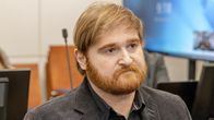 Parrakas mies katsoo eteenpäin.