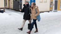 Otto Andersson och Mia Heijnsbroek-Wirén går på en snöig sandad gata. Ett ljusgult hus syns i bakgrunden.