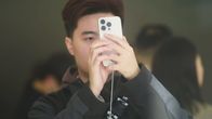 Asiakas tutkii iPhonea Applen lippulaivakaupassa Hangzhoussa.