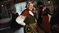 En kvinna i folkdräkt i museumsmiljö.