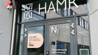 Rakennuksen pääsisäänkäynnin ovet. Ovissa harmaat karmit lasien ympärillä. Laseissa kirjoistusta.