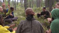 Hippiyhteisö Rainbow on kokoontunut ringissä soittamaan metsään 