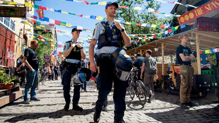 Poliiseja Pusher Streetillä kesäpäivänä, kadun yllä lippunauhoja.