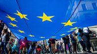 Ihmiset kannattelevat suurta EU:n lippua.