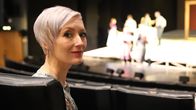 Kirjailija Merja Mäki istuu katsomossa Seinäjoen kaupunginteatterissa ja katsoo kameraan.