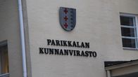 Rakennuksen seinässä on vaakuna. Vaakunan alla lukee Parikkalan kunnanvirasto